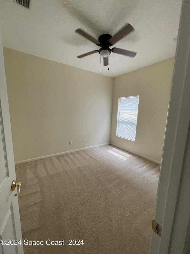 carpeted empty room featuring ceiling fan