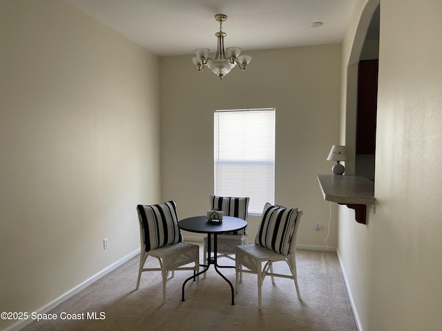 carpeted dining room featuring a chandelier