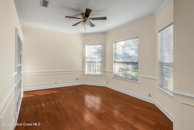 unfurnished room with a textured ceiling, dark hardwood / wood-style floors, ceiling fan, and ornamental molding