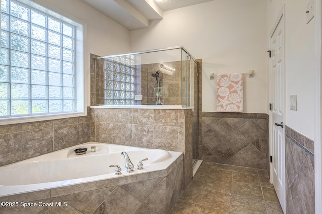 bathroom featuring tile patterned floors, separate shower and tub, and tile walls