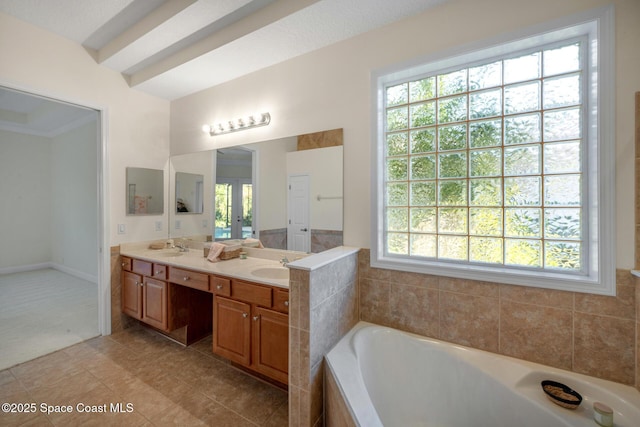 bathroom featuring tile patterned floors, a bathing tub, vanity, and a healthy amount of sunlight