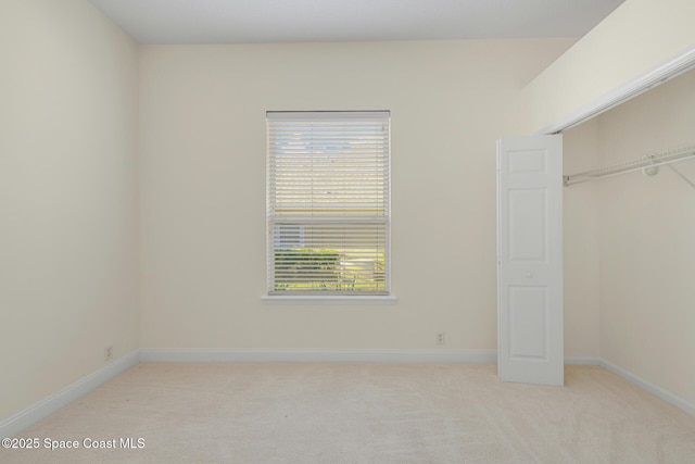 unfurnished bedroom featuring a closet and light colored carpet