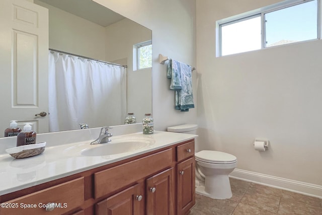 bathroom featuring vanity, a healthy amount of sunlight, and toilet