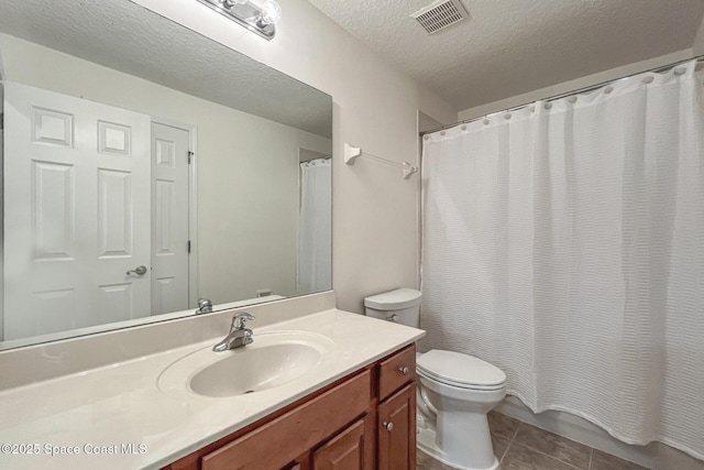 bathroom with tile patterned floors, vanity, toilet, and a textured ceiling