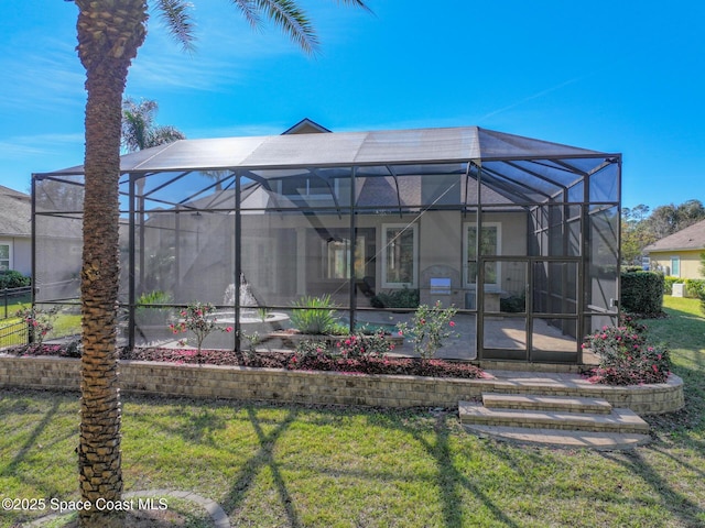 rear view of house featuring a yard and a lanai