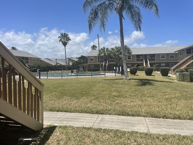 view of community with a yard and a swimming pool