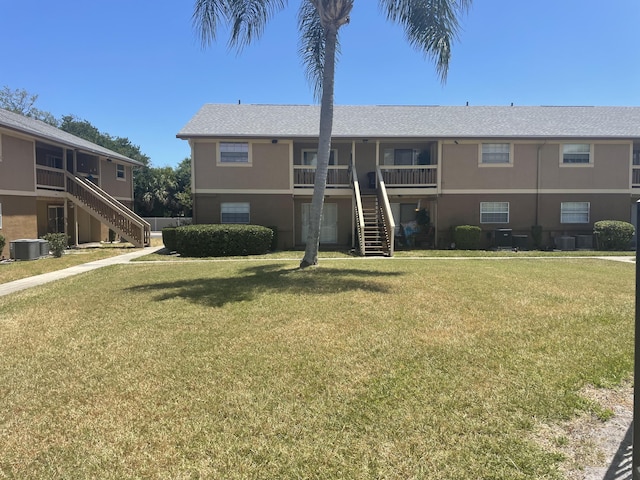 back of property featuring central AC and a yard