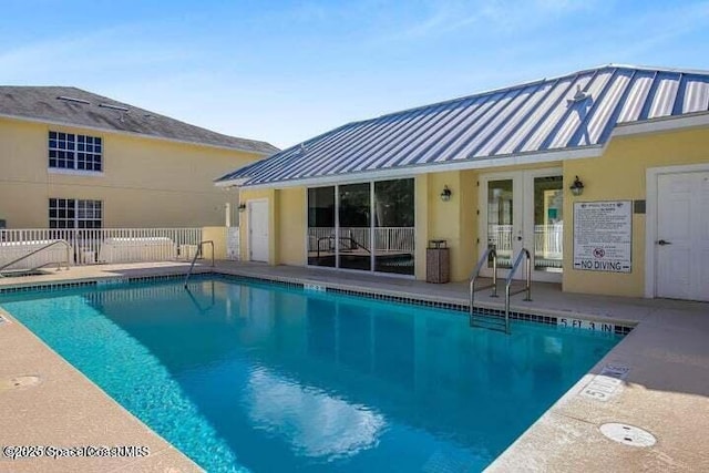 view of swimming pool featuring french doors