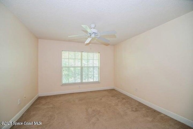 unfurnished room with light colored carpet and a textured ceiling