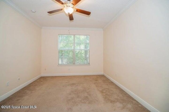 carpeted spare room featuring ceiling fan and crown molding