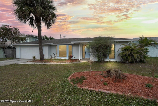 ranch-style home with a garage and a yard