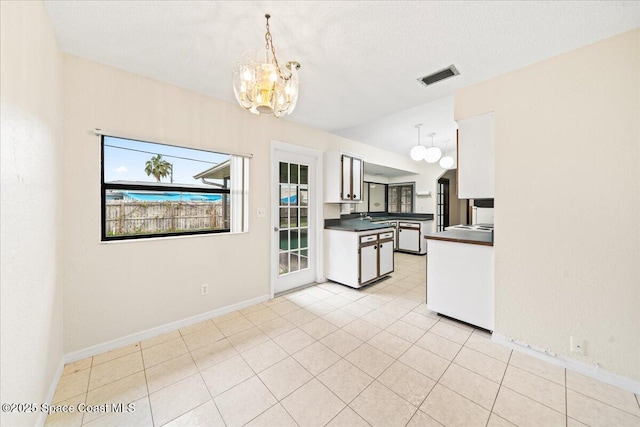 kitchen with white cabinets, pendant lighting, an inviting chandelier, and plenty of natural light