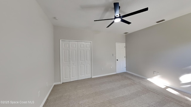 unfurnished bedroom featuring ceiling fan, a closet, and light carpet