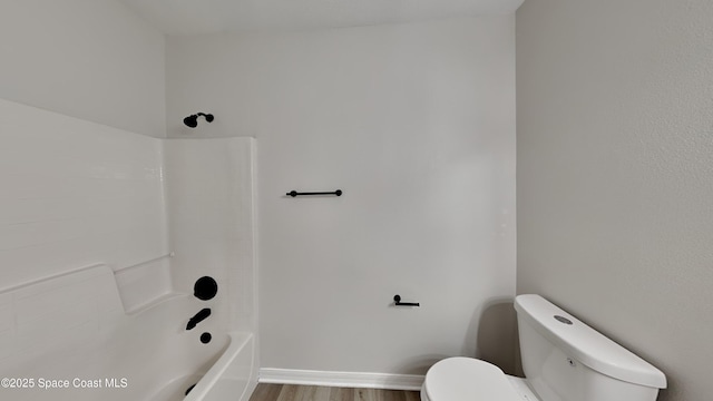 bathroom with shower / tub combination, hardwood / wood-style floors, and toilet