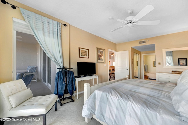 carpeted bedroom with ceiling fan, visible vents, and connected bathroom