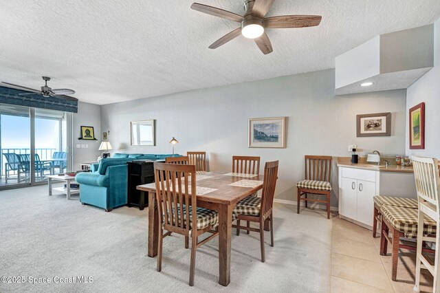 dining space with a textured ceiling, ceiling fan, light tile patterned floors, and baseboards