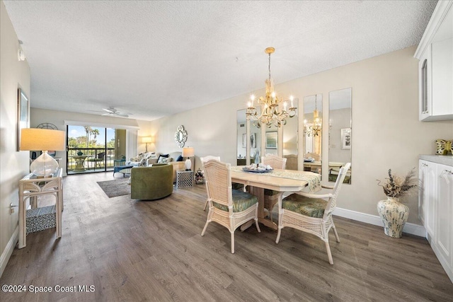 dining room with a textured ceiling, ceiling fan with notable chandelier, and dark wood-type flooring