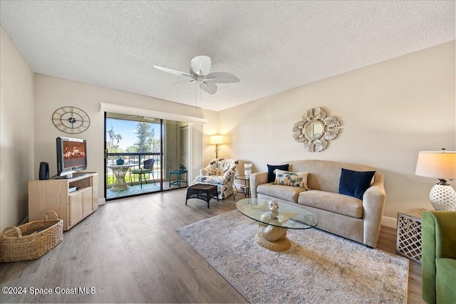 living room featuring hardwood / wood-style floors, ceiling fan, and a textured ceiling