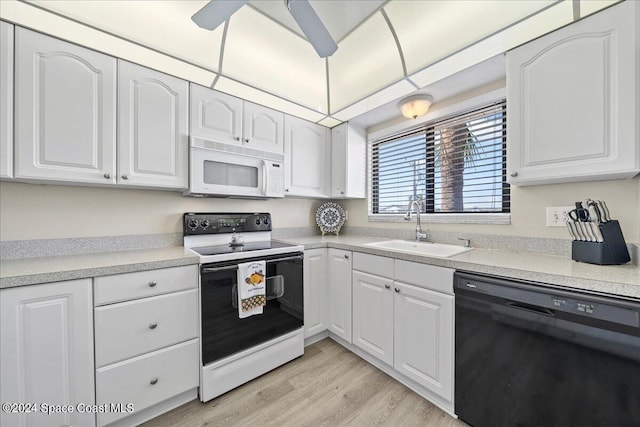 kitchen with white appliances, white cabinetry, and sink