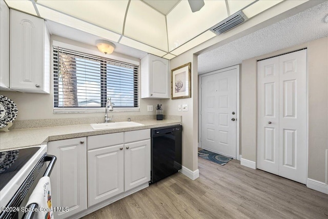 kitchen with white cabinets, sink, light hardwood / wood-style flooring, black dishwasher, and range