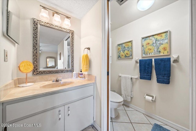 bathroom featuring tile patterned flooring, vanity, toilet, and a textured ceiling