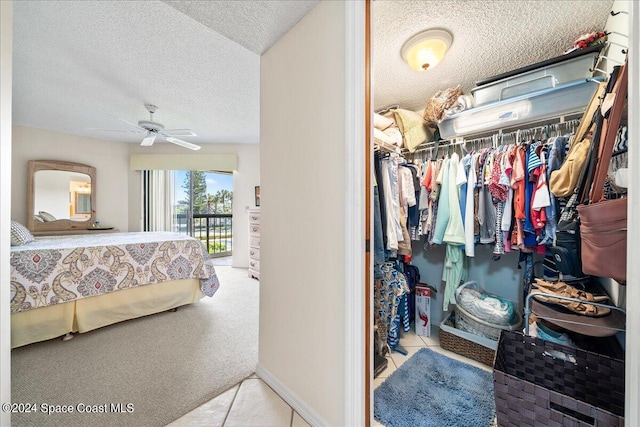 carpeted bedroom featuring access to exterior, ceiling fan, a closet, and a textured ceiling