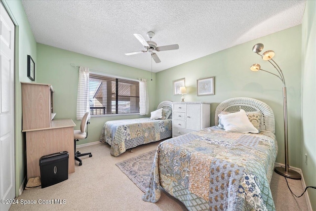 carpeted bedroom featuring ceiling fan and a textured ceiling