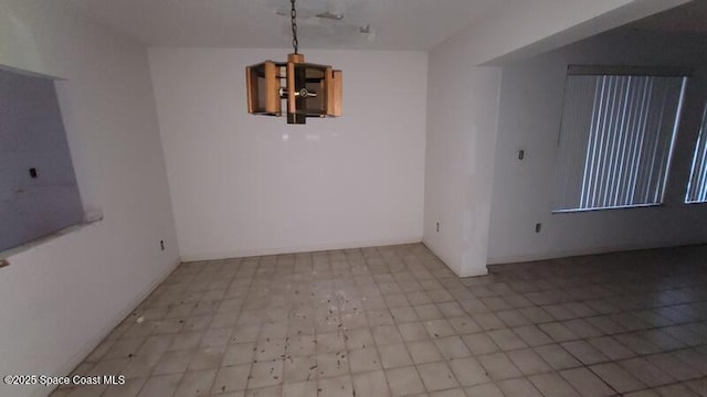 unfurnished dining area with a chandelier