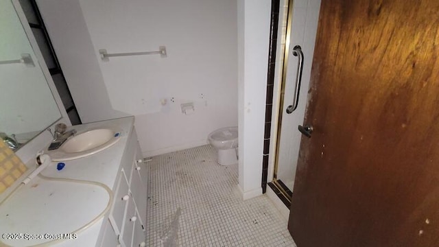 bathroom featuring tile patterned flooring, vanity, toilet, and a shower with door