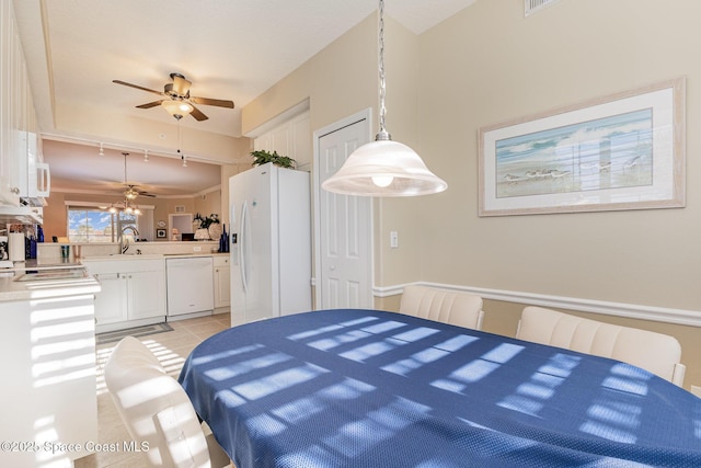 tiled dining area featuring ceiling fan and sink