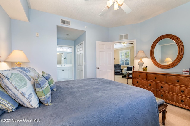 bedroom with light carpet, a textured ceiling, connected bathroom, and ceiling fan