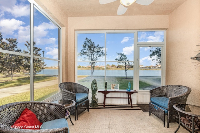 sunroom / solarium with a water view, ceiling fan, and a healthy amount of sunlight