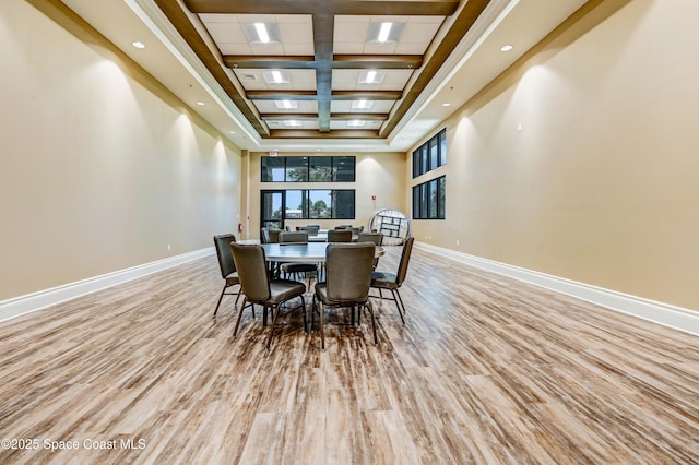 dining space with a high ceiling and light hardwood / wood-style flooring