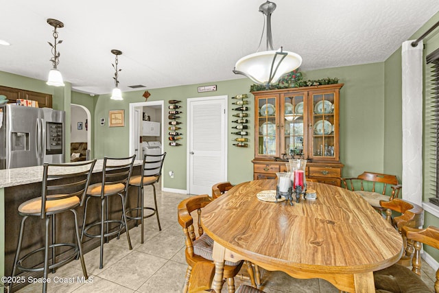 tiled dining room featuring a textured ceiling