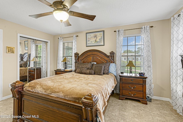 bedroom featuring light tile patterned floors, a textured ceiling, a closet, and ceiling fan