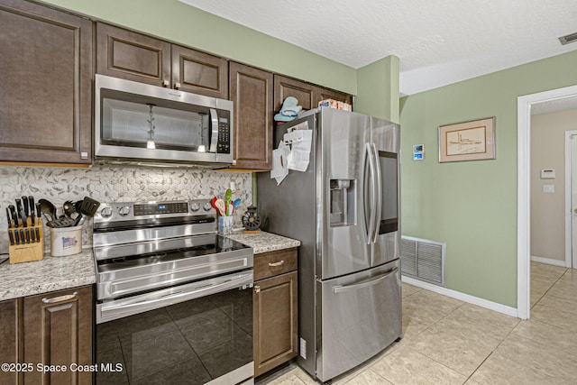 kitchen with tasteful backsplash, dark brown cabinets, stainless steel appliances, and a textured ceiling