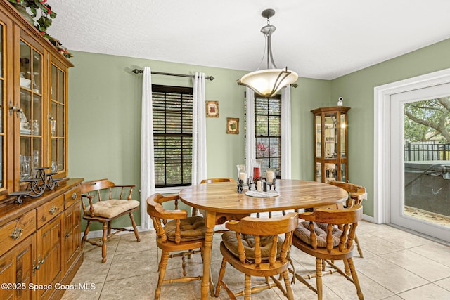 tiled dining room with a textured ceiling