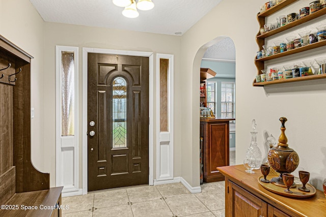 entryway with light tile patterned flooring and a textured ceiling