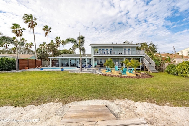 back of house featuring a fenced in pool, a yard, a balcony, and a patio