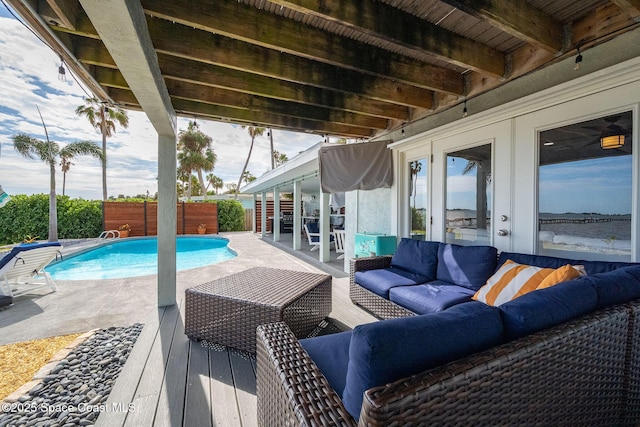 view of pool featuring an outdoor living space, a patio area, and french doors