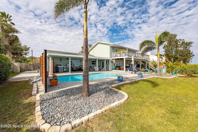 view of swimming pool featuring a patio area, a lawn, and ceiling fan