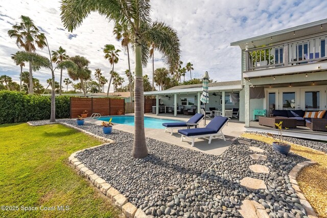 view of pool with a lawn, ceiling fan, an outdoor hangout area, french doors, and a patio