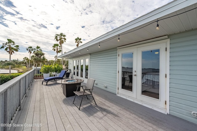 wooden deck featuring an outdoor fire pit and french doors