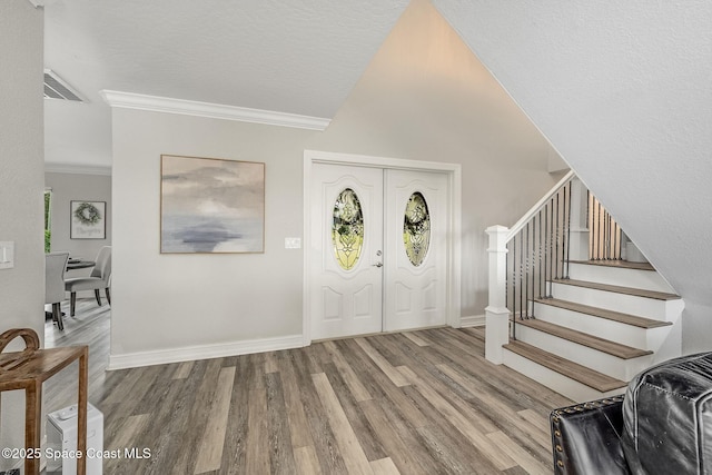 foyer entrance featuring a textured ceiling, crown molding, and hardwood / wood-style floors