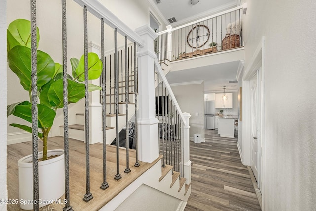 stairway featuring wood-type flooring and crown molding