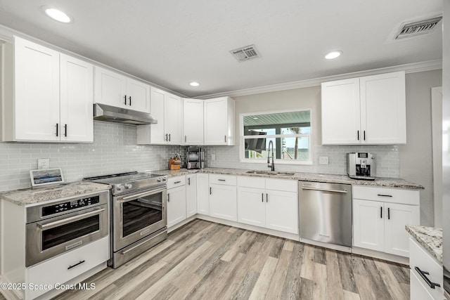 kitchen featuring appliances with stainless steel finishes, white cabinets, and sink