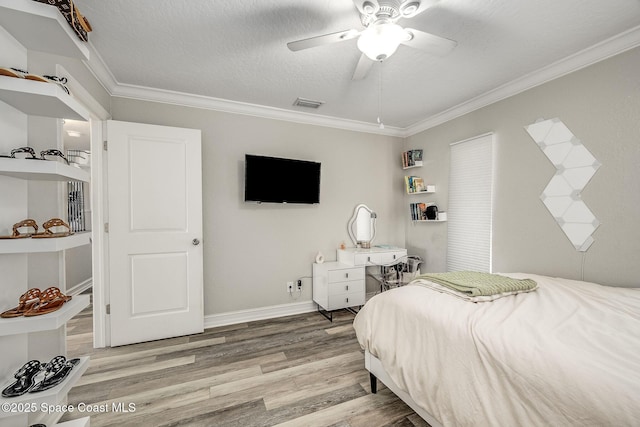 bedroom featuring ceiling fan, light hardwood / wood-style floors, a textured ceiling, and crown molding