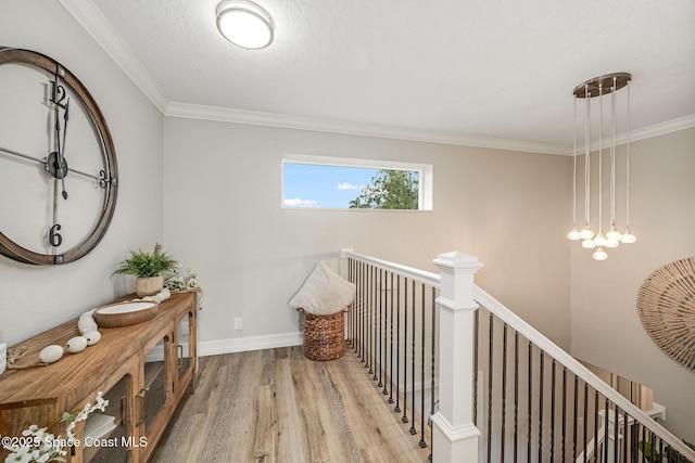 hall featuring a textured ceiling, crown molding, and light hardwood / wood-style floors