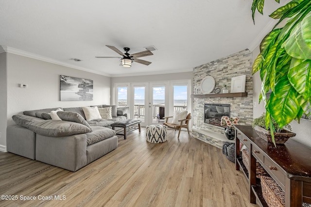 living room with a water view, ceiling fan, crown molding, and light hardwood / wood-style flooring