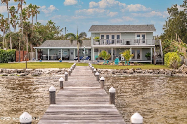 back of property featuring a water view, french doors, a lawn, and a patio area